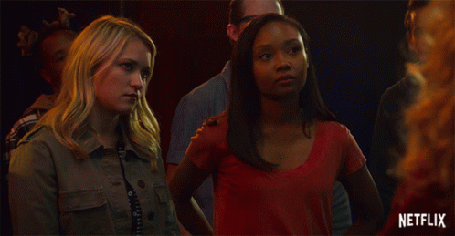 Two Women Standing Next To Each Other With A Netflix Logo In The Background GIF