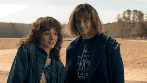 Two Women Standing Next To Each Other With One Wearing A Shirt That Says Be Meup GIF