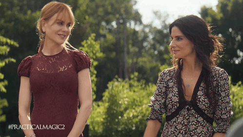 two women standing next to each other with #practicalmagic2 on the bottom right