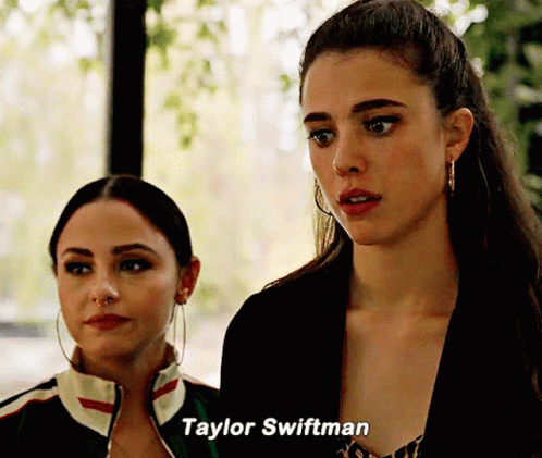 Two Women Standing Next To Each Other With Taylor Swiftman Written On The Bottom GIF