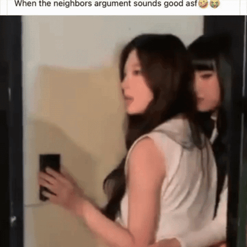 Two Women Standing Together One Holding Phone