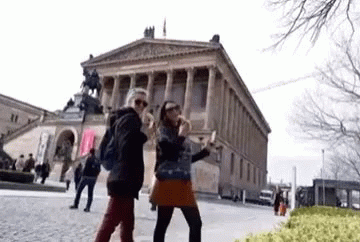 Two Women Taking Selfie in Front of Building