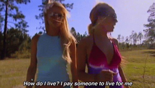 Two Women Walking In A Field With The Words How Do I Live I Pay Someone To Live For Me On The Bottom GIF