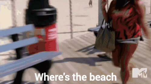 Two Women Walking On A Boardwalk With The Words " Where 'S The Beach " Written On The Bottom GIF