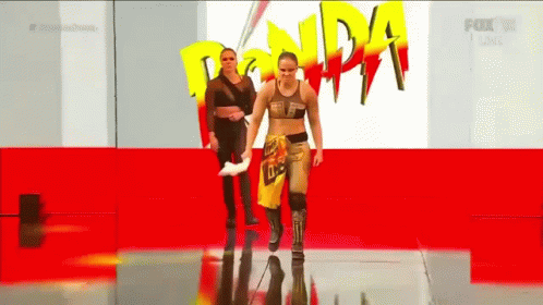 Two Women Walking Red Carpet Ronda Rousey Sign