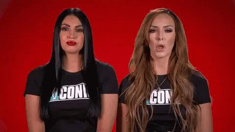 Two Women Wearing Black Shirts With The Word Con On Them GIF