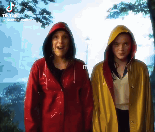 Two Women Wearing Red And Yellow Raincoats Are Standing Next To Each Other GIF