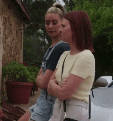 Two Women With Crossed Arms By White Car GIF