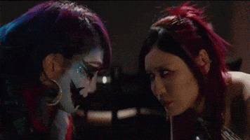 Two Women With Faces Painted Different Colors