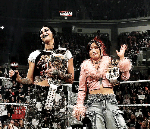 Two Women Wrestling in Ring Saying Raw