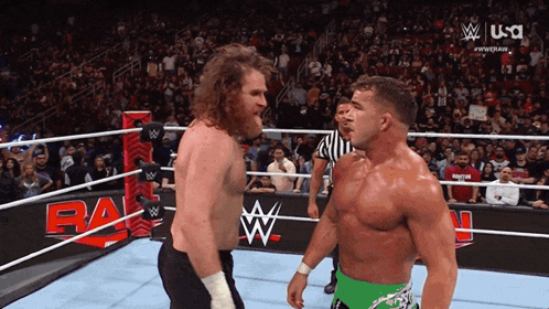 Two Wrestlers Are Facing Each Other In A Wrestling Ring With A Usa Logo Behind Them GIF