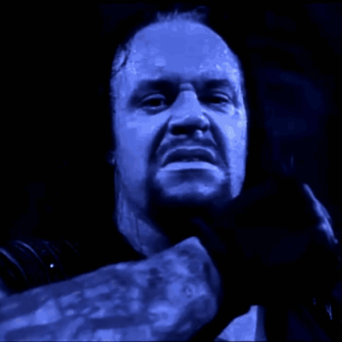 Two Wrestlers Are Fighting In A Wrestling Ring With A Crowd Watching In The Background GIF