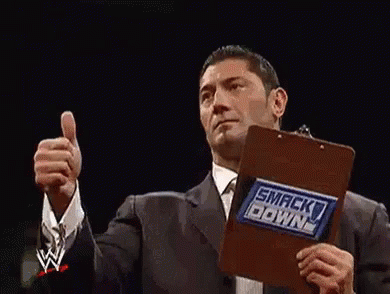 Two Wrestlers Are Giving A Thumbs Up In A Wrestling Ring . GIF