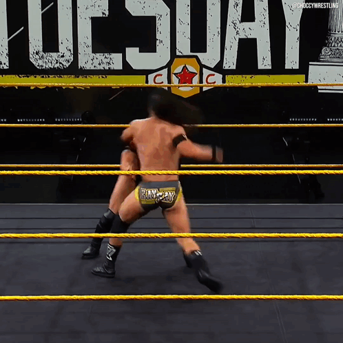 Two Wrestlers Are In A Ring With The Word Tuesday In The Background GIF