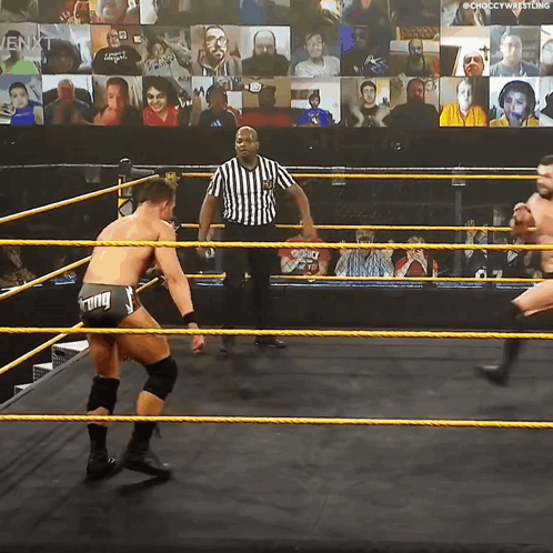 Two Wrestlers Are In A Wrestling Ring With A Referee In Front Of A Crowd GIF