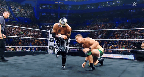 two wrestlers are in a wrestling ring with a sign that says ' w ' on it