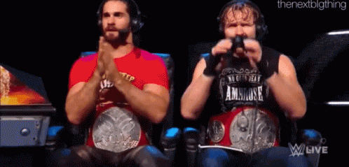 Two Wrestlers Are Sitting Next To Each Other With Their Hands Folded . GIF