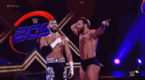 Two Wrestlers Are Standing In Front Of A Sign That Says 20 GIF