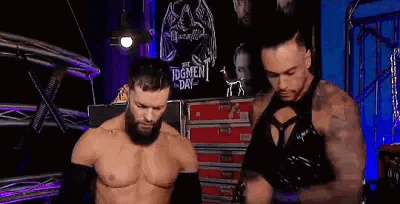 Two Wrestlers Are Standing Next To Each Other In A Ring . GIF