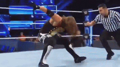 Two Wrestlers Are Wrestling In A Ring With A Referee Watching GIF