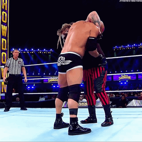 Two Wrestlers Are Wrestling In A Ring With A Sign That Says Super Showdown GIF