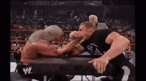 Two Wrestlers Arm Wrestling in a Ring