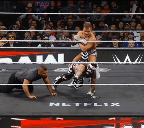Two Wrestlers In A Ring With A Netflix Logo In The Background GIF
