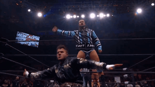 Two Wrestlers In A Ring With A Sign That Says Aew All In On It GIF