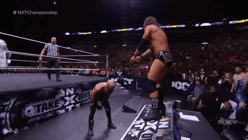 Two Wrestlers In A Ring With A Sign That Says " Take Over " GIF