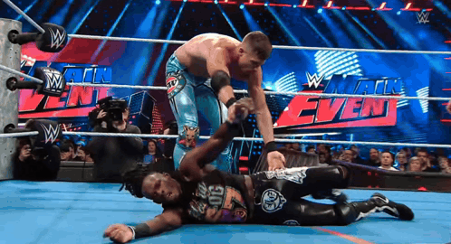 two wrestlers in a wrestling ring with a sign that says w