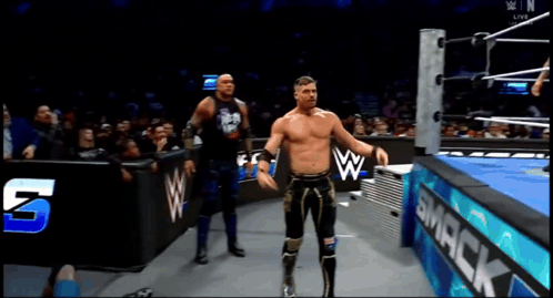 two wrestlers in a wrestling ring with a smack sign in the background