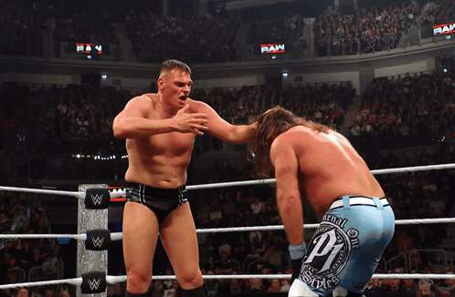 Two Wrestlers In A Wrestling Ring With One Wearing A Pair Of Shorts With The Letter P On Them GIF