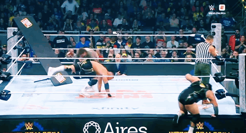 Two Wrestlers in Ring With Aires Written on Side