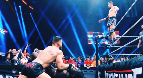 Two Wrestlers in Ring with New York Sign