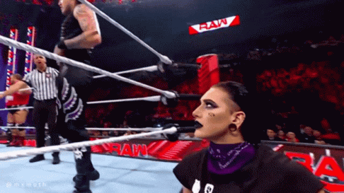 Two Wrestlers In Ring With Raw Sign GIF
