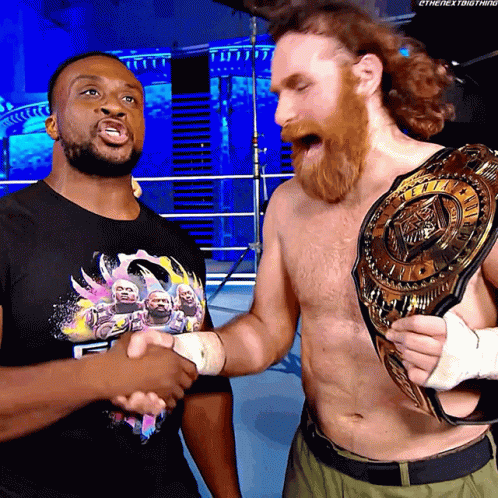 Two Wrestlers Shaking Hands With One Wearing A T-Shirt That Says ' Ethenextbigthing ' On It GIF