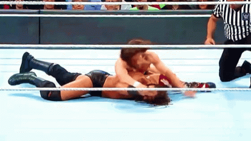 Two Wrestlers Wrestling In Ring With Referee GIF
