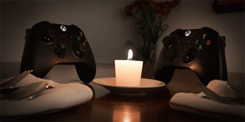 Two Xbox Controllers Next to Lit Candle
