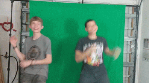Two Young Boys Are Dancing In Front Of A Green Screen GIF