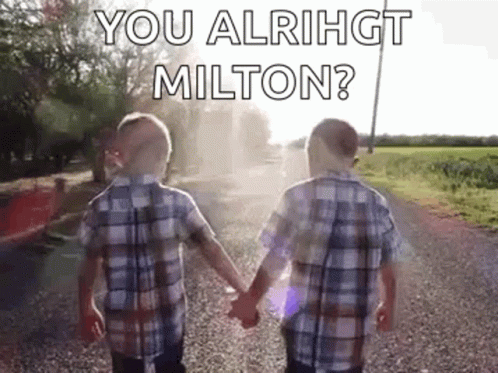 Two Young Boys Are Holding Hands On A Gravel Road . GIF