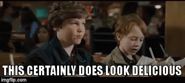 Two Young Boys Are Sitting At A Table In A Restaurant And Eating . GIF