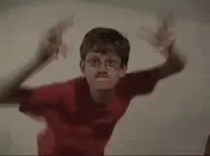 Two Young Boys Are Standing Next To Each Other In A Room . GIF