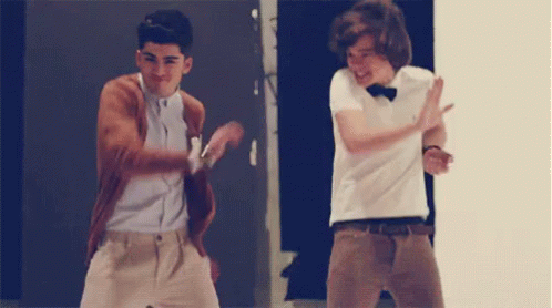 Two Young Men Are Dancing Together In Front Of A Door . GIF