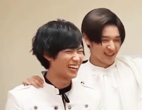 Two Young Men Are Laughing And Hugging Each Other . GIF