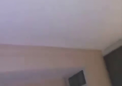 Two Young Men Are Laughing And Looking Up At The Sky While Sitting On A Bed . GIF