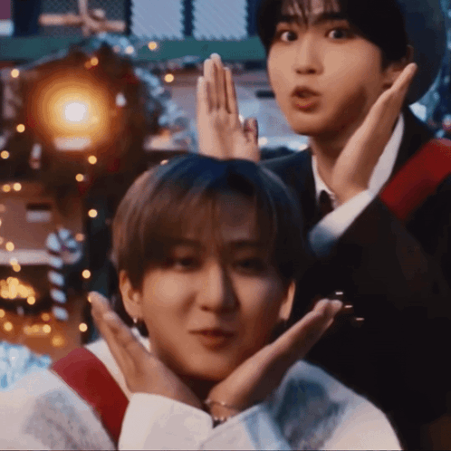 Two Young Men Are Making Funny Faces With Their Hands Over Their Faces GIF