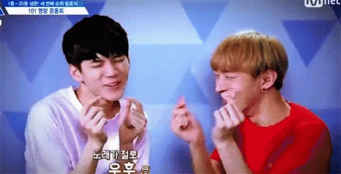 Two Young Men Are Making Heart Shaped Fingers With Their Hands . GIF