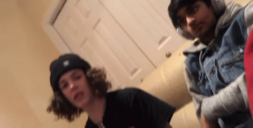 Two Young Men Are Posing For A Picture Together In A Room . GIF