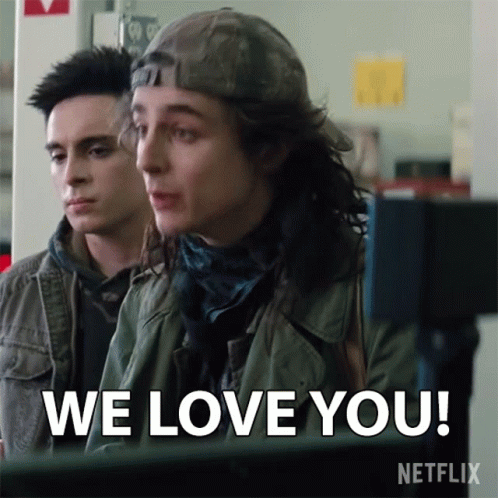 Two Young Men Are Sitting In Front Of A Computer And One Of Them Says We Love You GIF