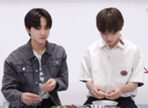 Two Young Men Are Sitting Next To Each Other And Playing With A Toy . GIF